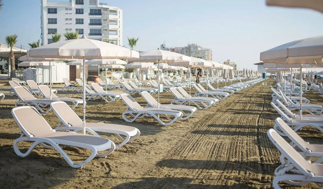 Nardi Omega napozóágyak sora strandon, napernyőkkel